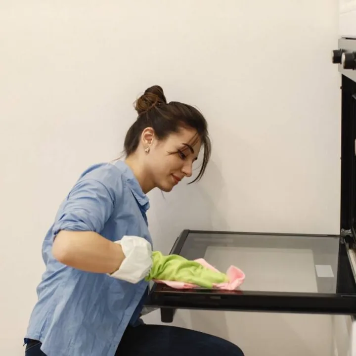 Professional cleaner wiping an oven door in a London Ontario home